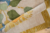 Thick plush pile of the rolled Art Deco rug, showing ivory, green, and saffron floral designs.