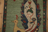 Peacock tail with germinating plant, jade green field, and boteh border on this Armenian rug.