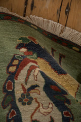 Rolled edge detail of pictorial Armenian rug: full pile, jade green, blue, and fringe.
