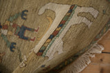 Plush beige pile, intricate banded border, and natural fringe detail on a vintage rug.