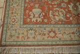 Detailed corner of the vintage Armenian rug, showing intricate floral palmettes, fringe, and a beige border.