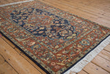 Rich texture and full pile of a vintage Armenian rug with a navy field and rust floral border.