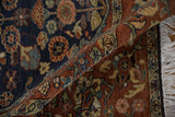 Close-up of the dense pile, showing navy and rust floral patterns and white fringe on a vintage rug.