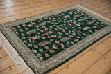 Fringe and border of an emerald green Armenian Hamadan rug, showing germinating plant motifs.