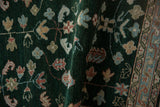 Unusual deep emerald green pile of vintage Armenian rug with colorful germinating plant motifs.