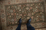 Intricate boteh and pinwheel floral motifs in copper and blue on a deep sage green field.