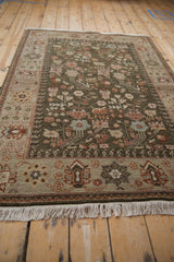 Angled corner view of a vintage Armenian rug highlighting its full pile and floral pattern in sage and beige.