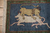 Armenian pictorial rug displaying the lion's head, mane, and emerald green geometric border.