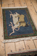 Armenian pictorial rug: lion and prey on dark denim blue, emerald green border.