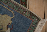 Pictorial Armenian rug corner showing emerald green border, visible side cording, and beige fringe.