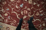 Expressive vinery and blue bell blossoms on the plush wine red field of an Armenian carpet.