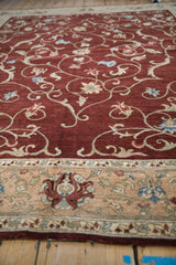 Angled view of a vintage Armenian rug, highlighting its plush wine-red pile and detailed border.