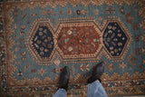 A close view of the geometric bird and plant motifs within the rug's triple medallion.