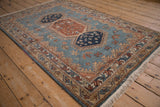 Angled view showing the plush pile of a vintage Armenian rug with geometric medallions.
