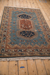 Angled view showing the plush pile and geometric bird motifs of a vintage Armenian rug.