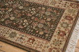 Corner detail of a vintage Armenian rug showing the dense olive pile, beige floral border, and clean ivory fringe.