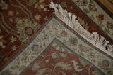 A corner view of the vintage Armenian rug showing its intact selvedge and full ivory fringe.