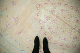Low pile texture and even wear on a distressed Bulgarian carpet with magenta floral details.