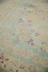 Detail of speckled low pile on a distressed rug with magenta florals and powder blue accents.
