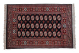 Vintage fine Bokhara rug with repeating geometric gul medallions in brick red and ivory on a black field.