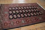 Angled view of a vintage Bokhara rug showing its plush, lustrous pile and geometric gul design.