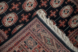 A folded corner of a fine Bokhora rug showing the plush wool pile, original selvage, and ivory fringe.