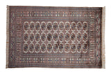 A fine vintage Bokhara rug with repeating geometric gul medallions in navy blue, sandalwood, and dusty blue.
