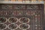 Finely woven corner of a vintage Bokhara rug with detailed geometric borders and original white fringe.