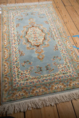 Detailed Rococo stylized floral vinery and scalloped contour on the dusty denim blue Kerman design rug.