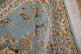 Indian Kerman rug with plush dusty blue pile, colorful floral vinery, and ivory fringe.