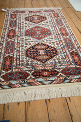 Vintage Indian Caucasian design rug corner with rust and navy geometric multi-cartouche border.