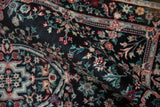 Full pile height of the vintage Savonnerie design rug, showcasing black, red, and turquoise blossoms.