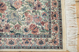 Corner detail of Pakistani vintage rug, showing dense multi-petaled flowers, blue border, and ivory fringe.