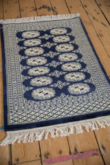 Hand-knotted vintage Bokhara rug with geometric guls and nuanced floral border designs.