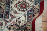 Rolled edge of vintage Pakistani Isfahan carpet with short pile, cherry red border, and arabesque motifs.