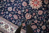 Vintage Pakistani Isfahan rug's navy field with blush and ivory floral vinery, underfoot detail.