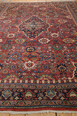 Angled view along a vintage Persian Mahal carpet, showing its dense field of floral palmettes.