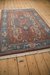 Shallow carved contour on vintage Indian Serapi rug, highlighting floral palmettes and rose and blue colors.
