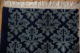 Plush pile and clean fringe on the expertly finished corner of the blue Damask rug.