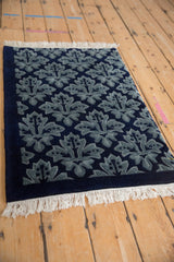 Vintage Indian Damask style rug with a full, sculpted pile in shades of blue, viewed from an angle.