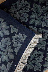 Vintage rug corner showing the hand-knotted back, full pile, and secured ivory fringe.