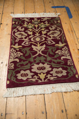 Bottom corner of Indian Savonnerie rug, with intact fringe, burgundy, beige, green arabesques.