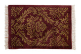 Vintage Indian rug with a carved damask pattern of serrated leaves in dark beige on a burgundy field.