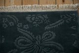Original ivory fringe and side cord selvage on a vintage rug with a carved tonal blue floral pile.