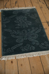 Angled view of a vintage Indian rug's full pile, showing the carved tone-on-tone floral design.