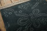 The full, plush pile of a vintage Indian rug with its shallow carved floral design.