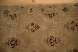 Textural detail of the shallow carved contour around trefoil plants in camel and sand.