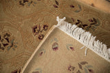 Folded corner of the vintage rug showing its hand-knotted back, carved pile, and clean fringe.
