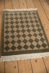 Contemporary Indian checkered design with carved texture, solid green border, and fringe.