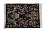 Vintage Indian Savonnerie rug mat: multi-color scrolled floral design on black ground.